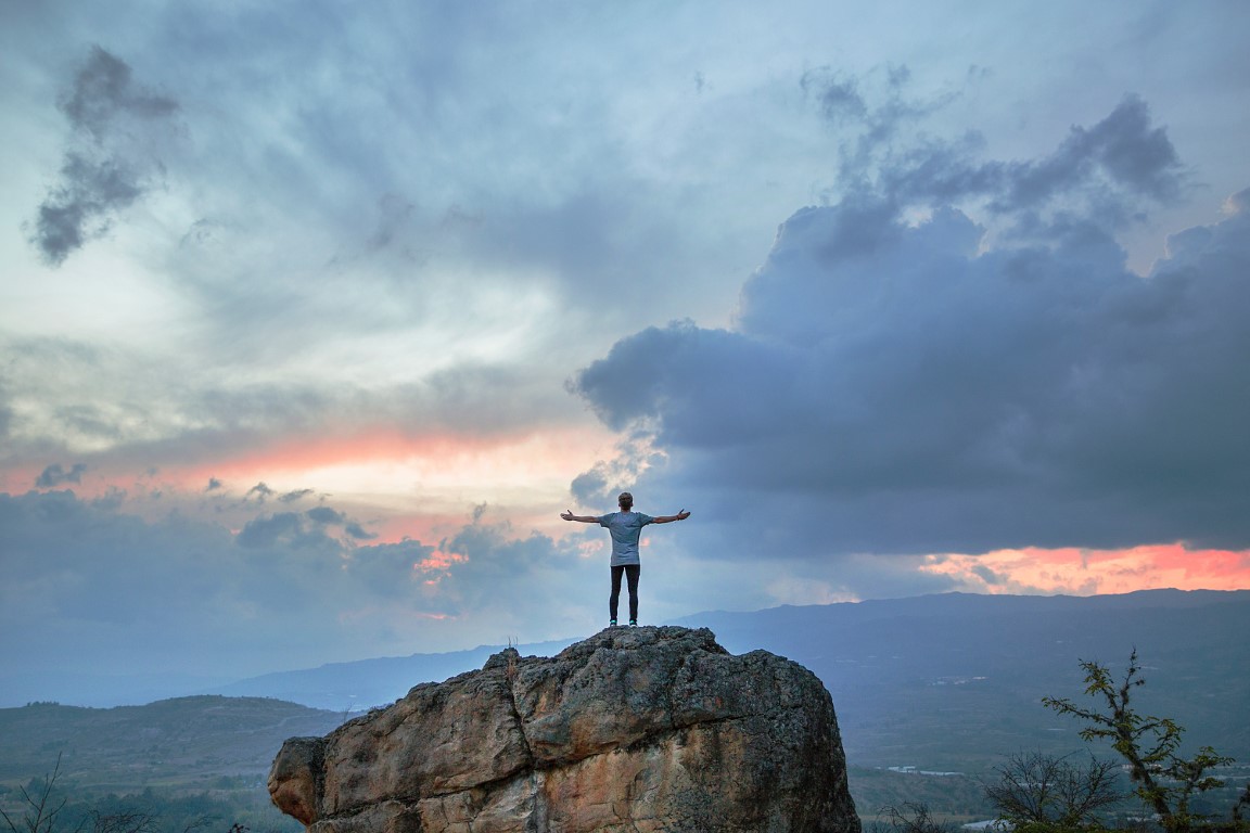 Photograph of one person standing on the rock